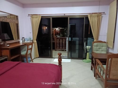 ein Schlafzimmer mit einem Bett, einem Schreibtisch und einem Tisch mit einem Schreibtisch in der Unterkunft Hostel samui Sunset in Ban Na We