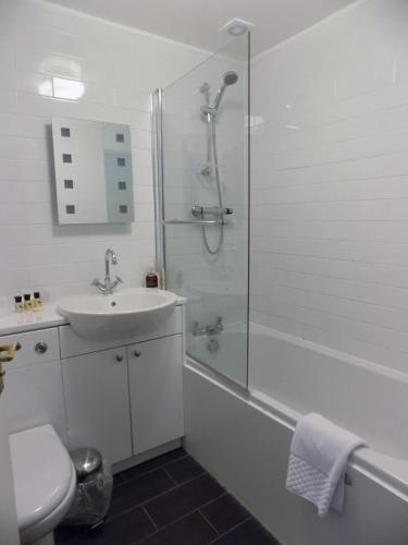 a bathroom with a shower and a sink and a toilet at The Cottage Inn in Craster