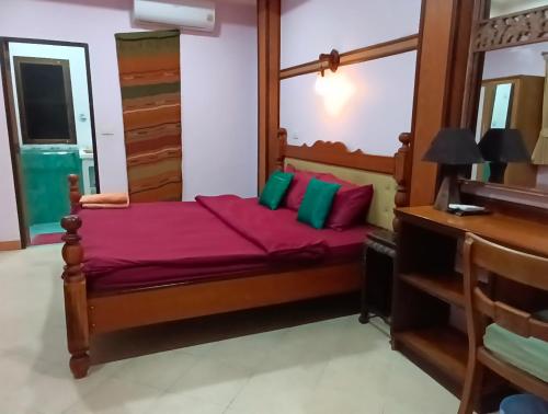 ein Schlafzimmer mit einem großen Holzbett und einem Schreibtisch in der Unterkunft Hostel samui Sunset in Ban Na We