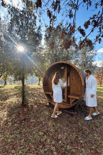 a man and a woman standing next to a wooden igloo at Glamping Il Rifugio dei Marsi in Ascoli Piceno