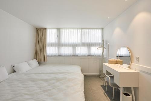 a bedroom with a bed and a desk and a mirror at soul stay 2 in Busan