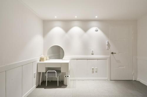a white bathroom with a sink and a mirror at soul stay 2 in Busan