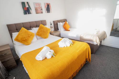 two beds with towel animals on top of them at Glenroy House Swansea in Swansea
