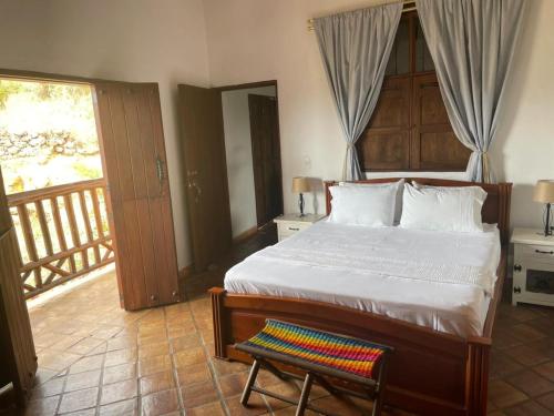 a bedroom with a bed and a chair and a balcony at Hotel Lengerke Barichara in Barichara