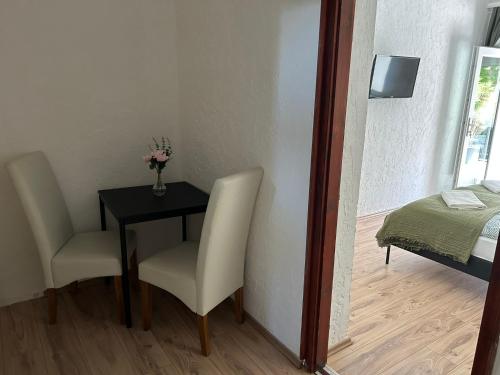 a room with a table and two chairs and a bed at Balaton Bloom 24 in Siófok