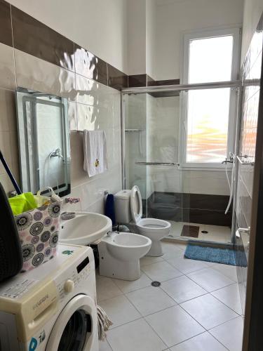a bathroom with a washing machine and a toilet at Seaside Escape in Draç