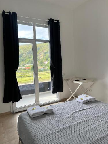 a bedroom with a bed and a large window at Seaside Escape in Draç