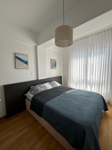 a bedroom with a bed and a large window at Hug and Fly Apartment in Skopje