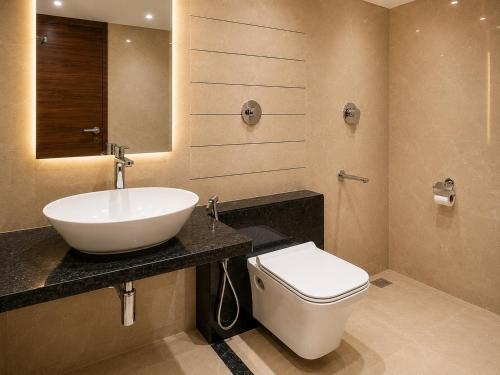 a bathroom with a sink and a toilet at Hotel Unnati Stay Inn Vijayapura By HRG in Bijāpur