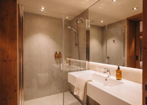 ein Badezimmer mit Waschbecken und Dusche in der Unterkunft Eringer Hotel in Hérémence