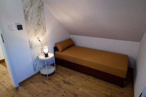 a small bedroom with a bed and a side table at DOMKI KASZUBY Cegła & Relaks in Stężyca