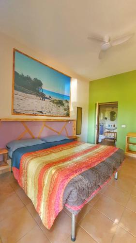a bedroom with a bed with a painting on the wall at B&B Las Piccas in Santa Maria la Palma
