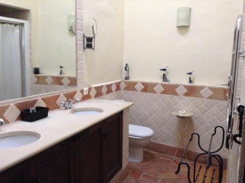 a bathroom with two sinks and a toilet at Casinha Antiga in Boliqueime
