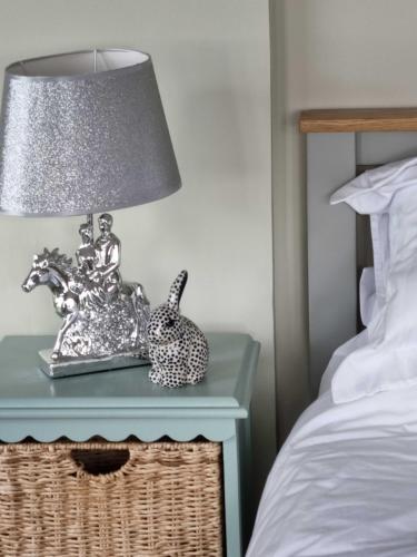 a lamp on a table next to a bed at Huntshaw Stables in Earlston
