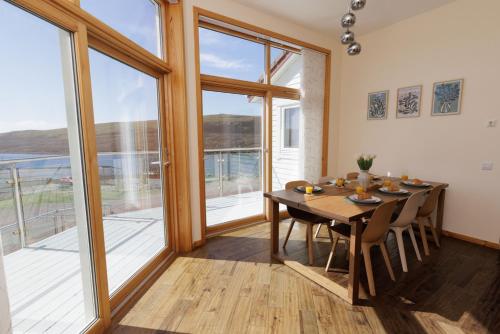 a dining room with a table and a large window at Bellevue House, Shetland Islands in Whiteness