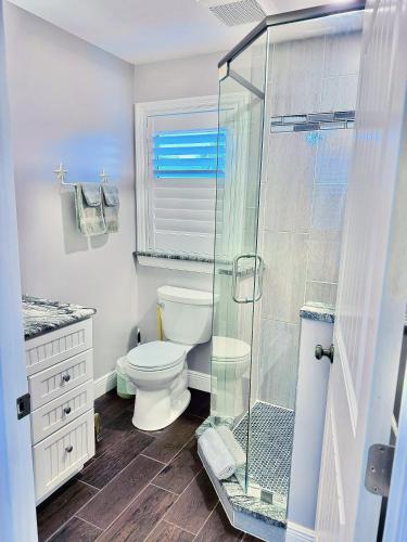 a bathroom with a toilet and a glass shower at Manatee River Bungalow in Bradenton