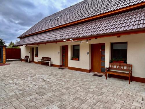 a building with a patio with two benches on it at BT Apartman in Miercurea-Ciuc
