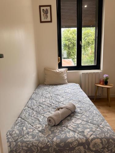 a bed with a towel laying on it in a bedroom at Escale Confort A1-2 Chambres Stationnement Facile in Roye