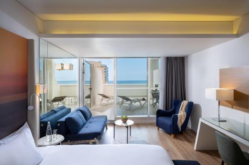 a hotel room with a bed and a living room at Leonardo Plaza Netanya Hotel in Netanya