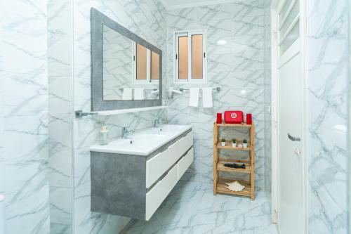 a white bathroom with a sink and a mirror at Royal Moroccan Suite Central Tangier in Tangier