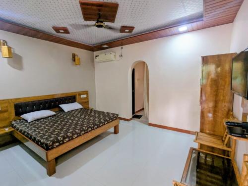 a bedroom with a bed in a room at Second Home Stays at Arnav Cottages Alibag in Alibaug