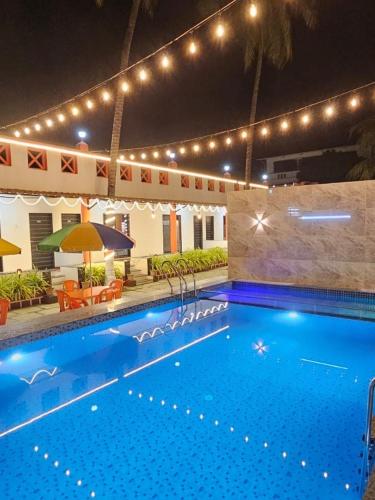 a large swimming pool with lights and a large swimming pool at Second Home Stays at Arnav Cottages Alibag in Alibaug