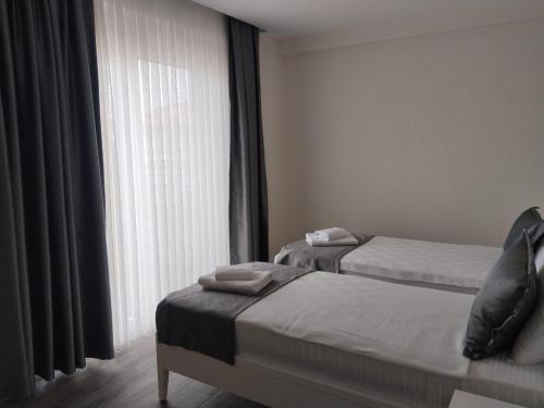 a hotel room with two beds and a window at Bacbery Butik Otel in Çeşme