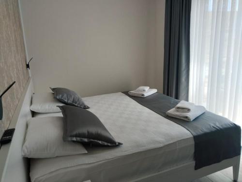 a bedroom with a bed with pillows and a window at Bacbery Butik Otel in Çeşme