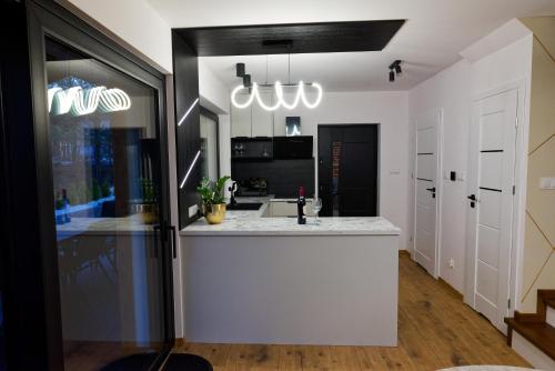 a kitchen with a white counter and a sink at DOMKI KASZUBY Cegła & Relaks in Stężyca