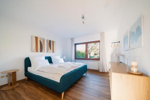 a bedroom with a blue bed in a room at Landhaus Mira in Witzenhausen