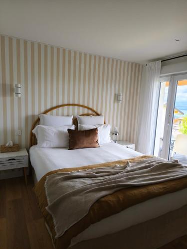 a bedroom with a large white bed with a window at Au coucher du lac in Publier