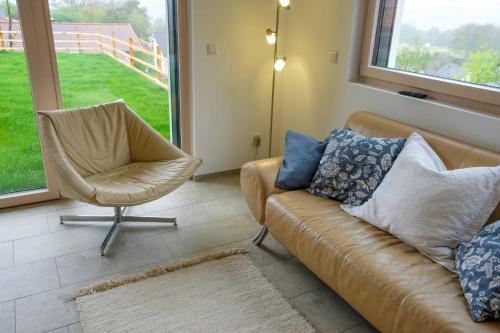 a living room with a couch and a chair at Ferienwohnung Weitblick im Dahner Felsenland in Bruchweiler-Bärenbach