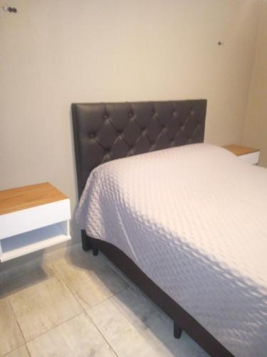 a bedroom with a bed and a nightstand next to it at Apart Trelew 1 in Trelew
