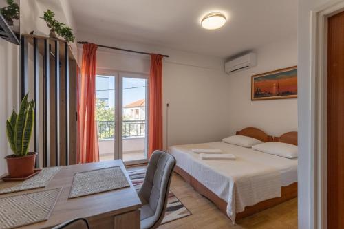 a bedroom with a bed and a table and a window at Apartman Lance in Kožino