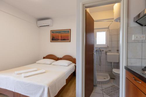 a bedroom with a bed and a shower and a toilet at Apartman Lance in Kožino