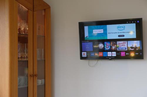 a flat screen tv sitting on a wall next to a cabinet at Ferienwohnung Weitblick im Dahner Felsenland in Bruchweiler-Bärenbach