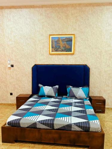 a bedroom with a bed with a blue and white comforter at Prestige A4 in Ouagadougou