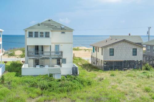 a house and a house on the side of a beach at Carolina Kai II - Kitty Hawk MP 3, 228 Yards to Beach, Ocean View, Pool, Hot Tub in Kitty Hawk