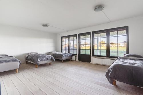 a white room with two beds and windows at Gula villan in Påarp