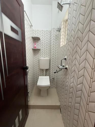 a bathroom with a toilet in a small room at Orchid 3BHK 3AC in New Town