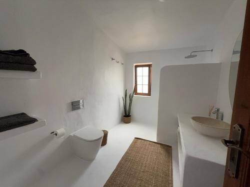 a white bathroom with a toilet and a sink at Villa Ann Lanzarote in Nazaret