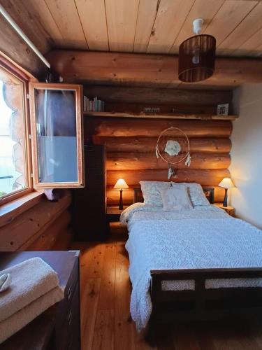 a bedroom with a bed in a log cabin at Lagarta La Fuste in Étival