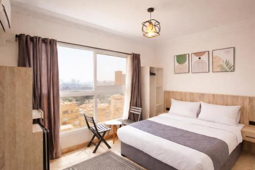 a bedroom with a bed and a large window at Nile X Hostel - Nile view in Cairo