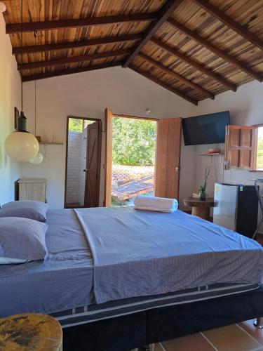 a bedroom with a large bed and a large window at Aires de Encanto in Curití