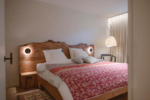 a bedroom with a large bed with a wooden headboard at B&B Hof Van Straeten in Jabbeke