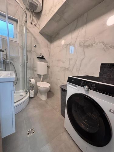 a bathroom with a washer and dryer in it at Apartments Šebin in Baška Voda