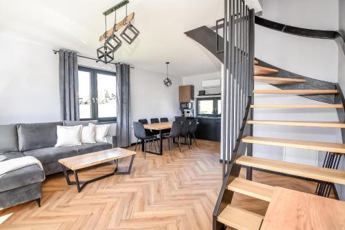 a staircase in a living room with a couch and a table at Maruszyna Resort & SPA in Zakopane