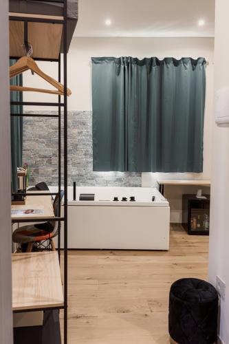 a bath tub in a room with a green curtain at La Mora Rooms in Linguaglossa