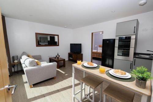 a kitchen and living room with a table with food on it at Bellevue Apartment, Shetland Islands in Whiteness
