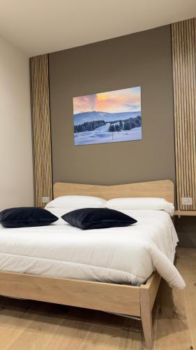 a bedroom with a large bed with two pillows at La Mora Rooms in Linguaglossa
